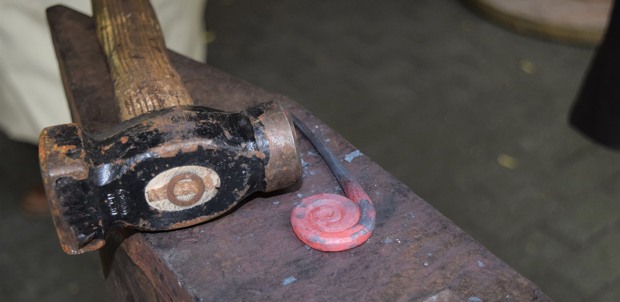 Red-hot metal being forged on anvil showing traditional blacksmithing process